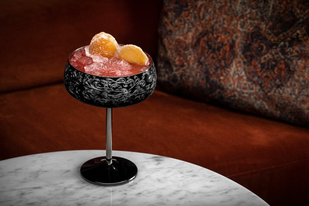 a glass with a drink and orange slices on it