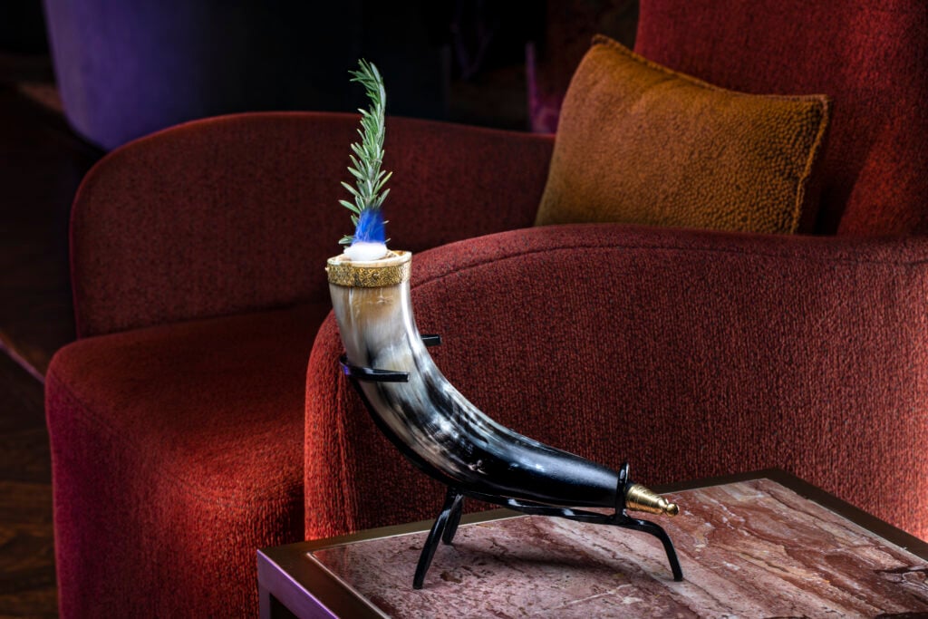 a horn shaped vase with a plant in it