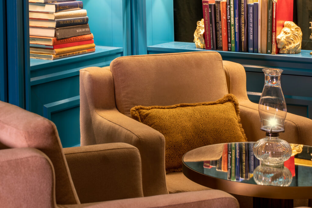 a chair with a pillow and a table with books on it