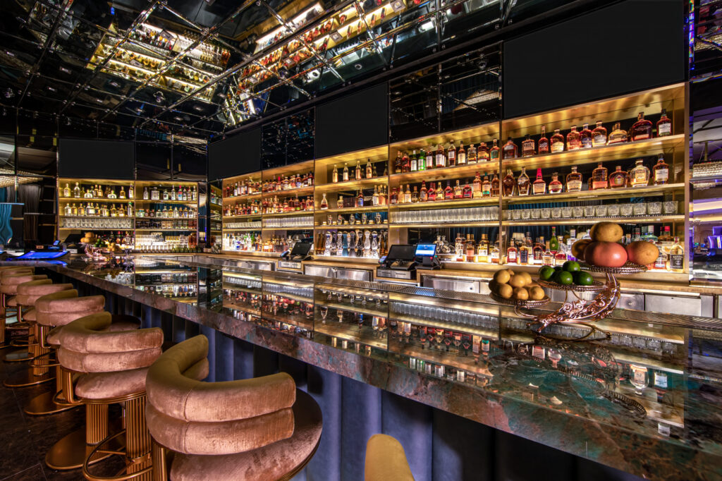 a bar with shelves of liquor and a glass shelf